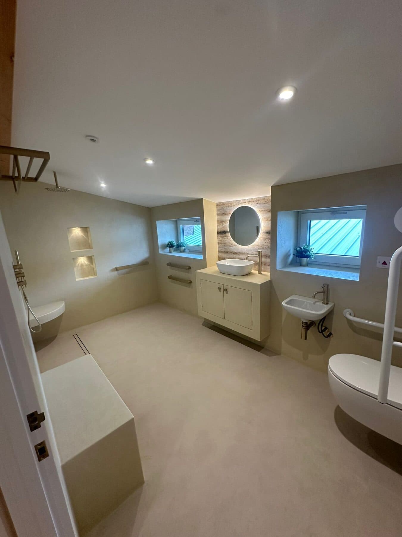 Wet room with downlights, a lit mirror over the basin and recessed lighting in the shower alcoves